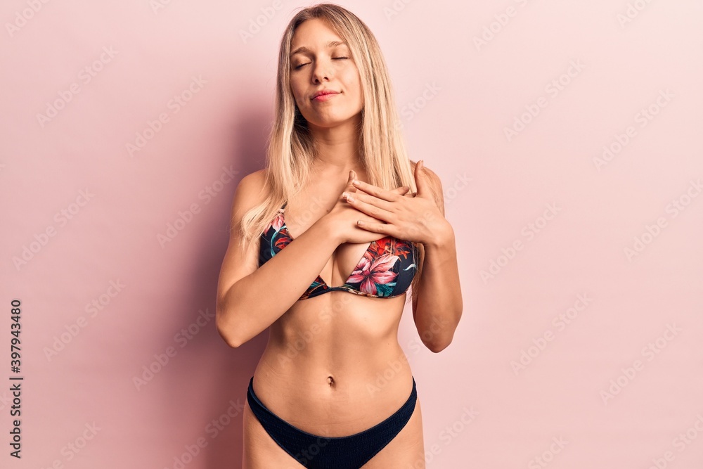 Obraz premium Young beautiful blonde woman wearing bikini smiling with hands on chest, eyes closed with grateful gesture on face. health concept.
