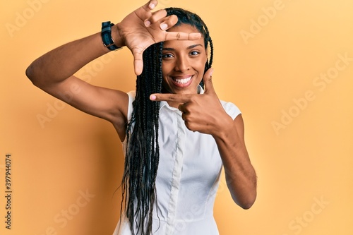 African american woman wearing casual clothes smiling making frame with hands and fingers with happy face. creativity and photography concept.