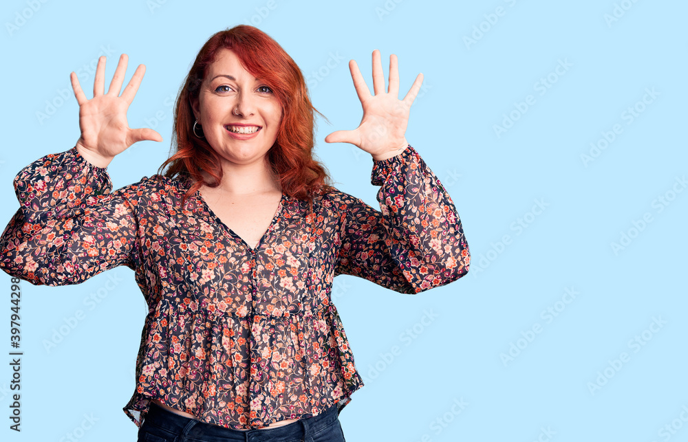 Young beautiful redhead woman wearing casual t-shirt showing and pointing up with fingers number ten while smiling confident and happy. Young beautiful redhead woman wearing casual t-shirt showing and pointing up with fingers number ten while smiling confident and happy.