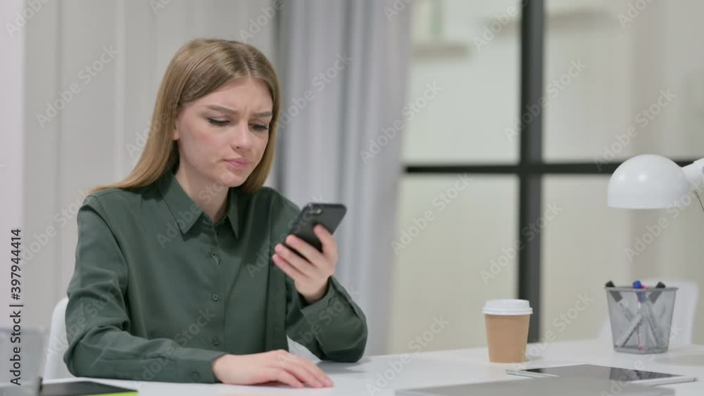 Upset Young Woman Reacting to Loss on Smartphone Upset Young Woman Reacting to Loss on Smartphone