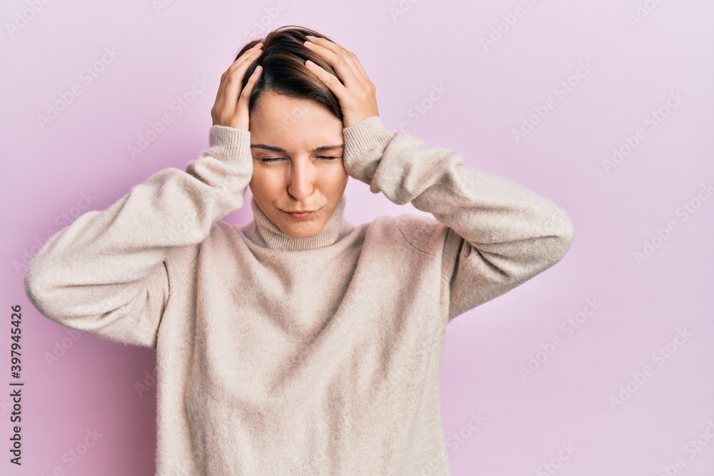 Young brunette woman with short hair wearing casual winter sweater suffering from headache desperate and stressed because pain and migraine. hands on head. Young brunette woman with short hair wearing casual winter sweater suffering from headache desperate and stressed because pain and migraine. hands on head.