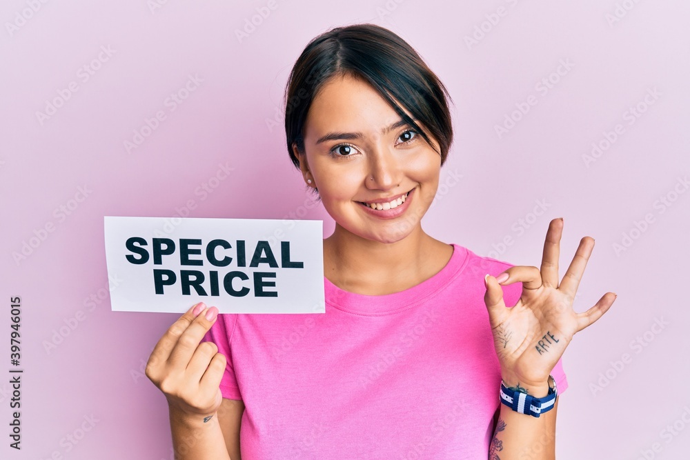 Beautiful young woman with short hair holding special price message doing ok sign with fingers, smiling friendly gesturing excellent symbol Beautiful young woman with short hair holding special price message doing ok sign with fingers, smiling friendly gesturing excellent symbol