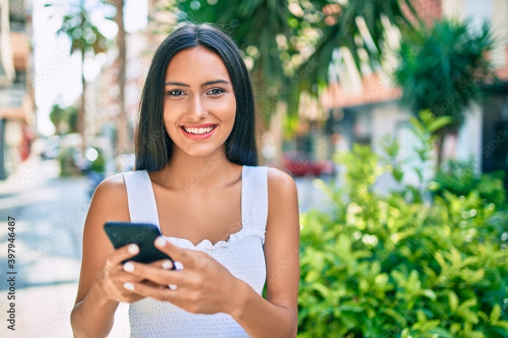Young latin girl smiling happy using smartphone at street of city. Young latin girl smiling happy using smartphone at street of city.
