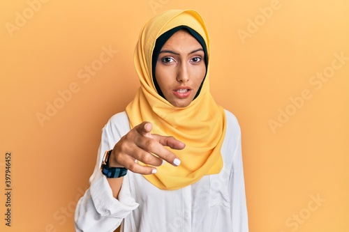 Young brunette arab woman wearing traditional islamic hijab scarf pointing displeased and frustrated to the camera, angry and furious with you © Krakenimages.com