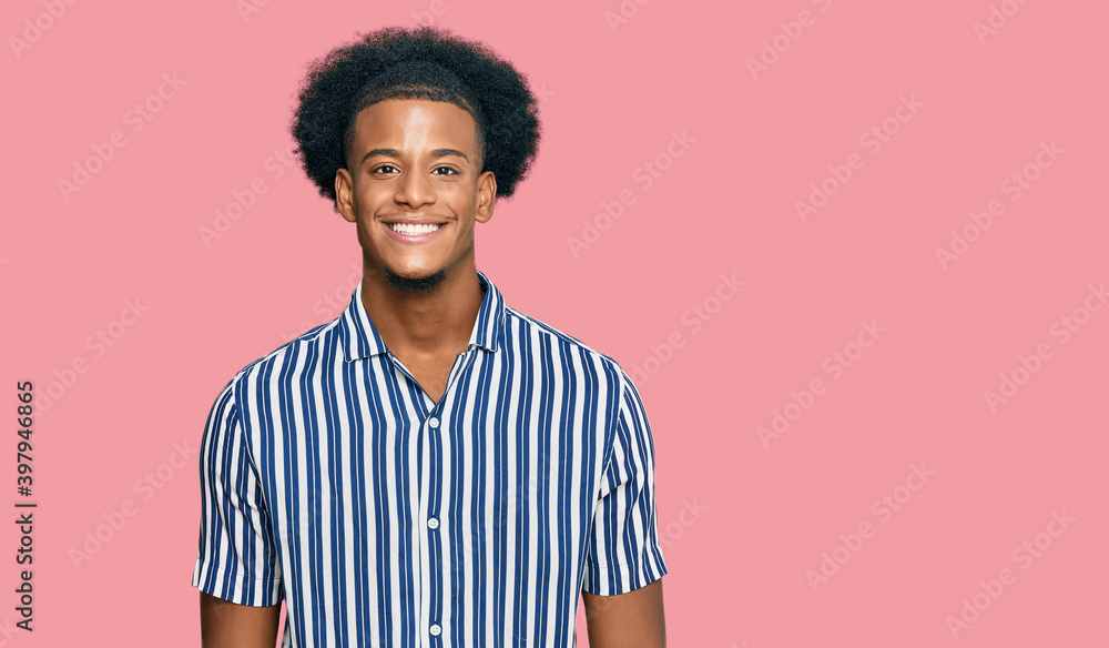 African american man with afro hair wearing casual clothes looking positive and happy standing and smiling with a confident smile showing teeth African american man with afro hair wearing casual clothes looking positive and happy standing and smiling with a confident smile showing teeth
