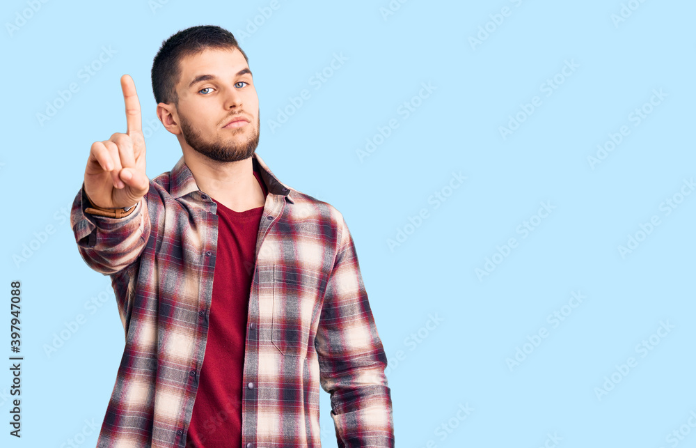 Young handsome man wearing casual shirt pointing with finger up and angry expression, showing no gesture Young handsome man wearing casual shirt pointing with finger up and angry expression, showing no gesture