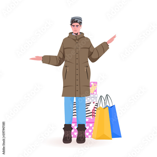 man in winter clothes standing near purchases new year christmas shopping seasonal sale concept full length vector illustration