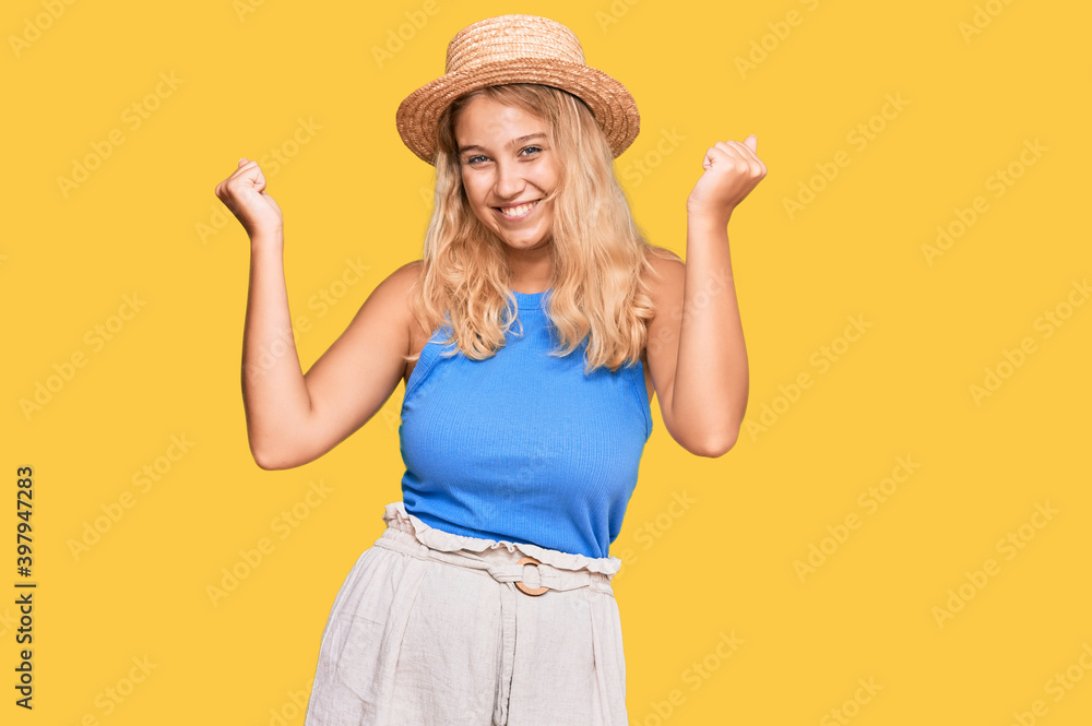 Young blonde girl wearing summer hat screaming proud, celebrating victory and success very excited with raised arms Young blonde girl wearing summer hat screaming proud, celebrating victory and success very excited with raised arms
