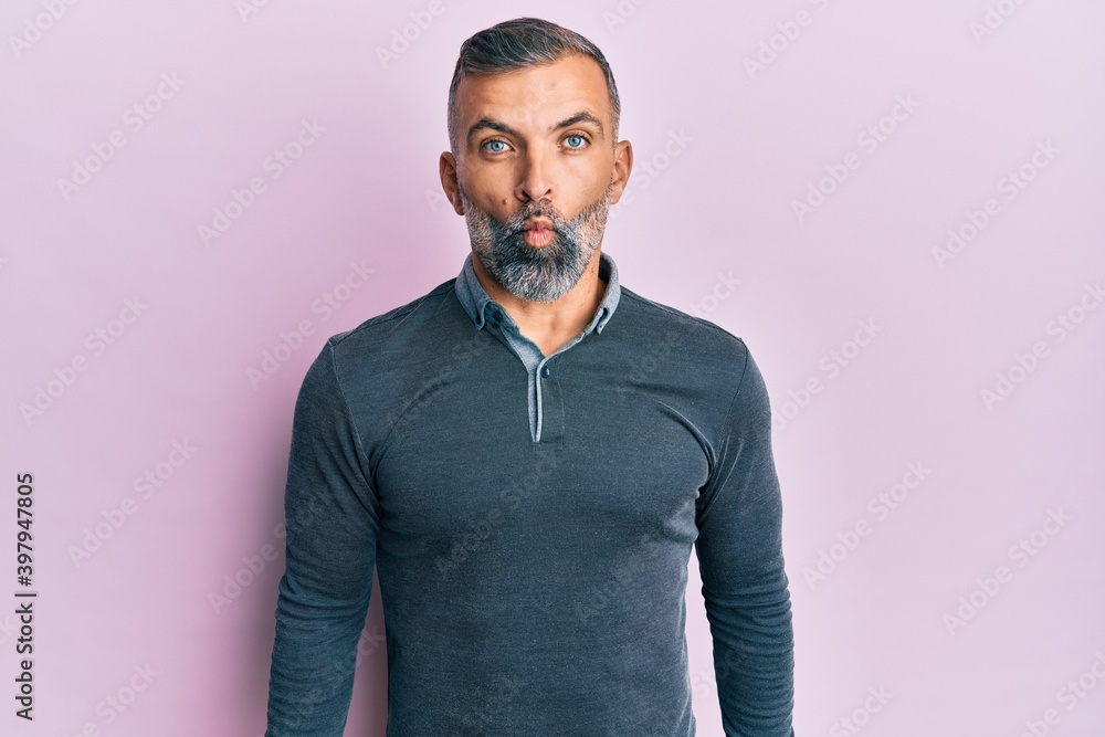 Middle age handsome man wearing casual clothes making fish face with lips, crazy and comical gesture. funny expression. Middle age handsome man wearing casual clothes making fish face with lips, crazy and comical gesture. funny expression.