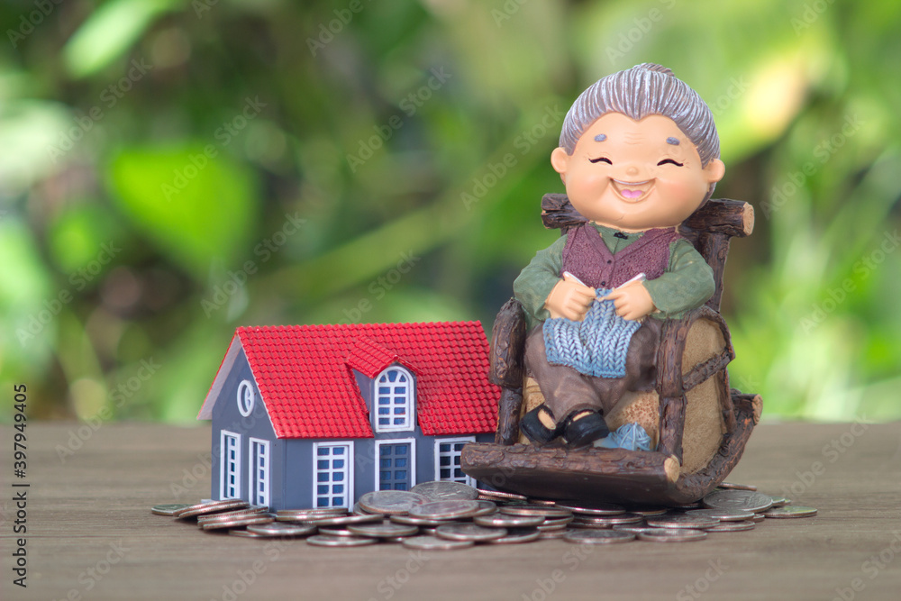 Φωτογραφία A model of an old woman sitting on a rocking chair and a model of a small house