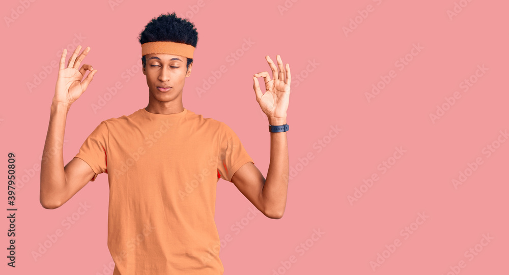 Fototapeta premium Young african american man wearing sportswear relax and smiling with eyes closed doing meditation gesture with fingers. yoga concept.