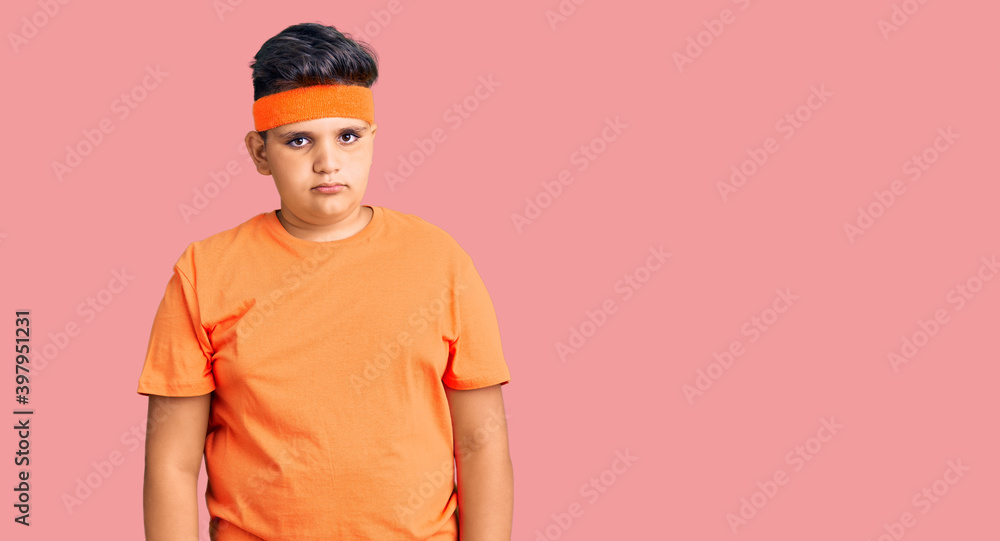 Little boy kid wearing sportswear relaxed with serious expression on face. simple and natural looking at the camera.
