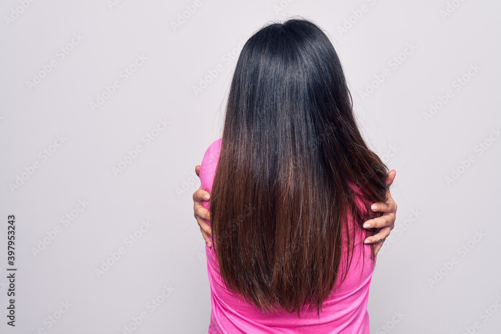 Young beautiful brunette woman wearing casual pink t-shirt standing over white background Hugging oneself happy and positive from backwards. Self love and self care Young beautiful brunette woman wearing casual pink t-shirt standing over white background Hugging oneself happy and positive from backwards. Self love and self care