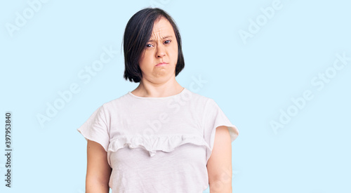 Brunette woman with down syndrome wearing casual white tshirt skeptic and nervous, frowning upset because of problem. negative person. © Krakenimages.com