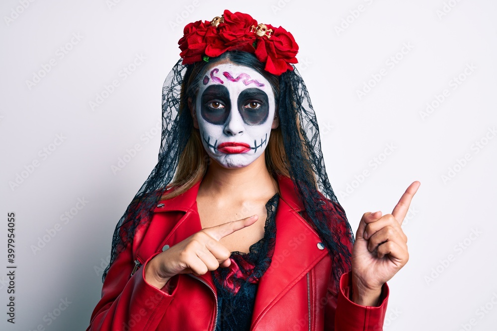 Woman wearing day of the dead costume pointing with fingers to the side depressed and worry for distress, crying angry and afraid. sad expression.