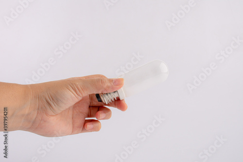 hand holding white light bulb on white background