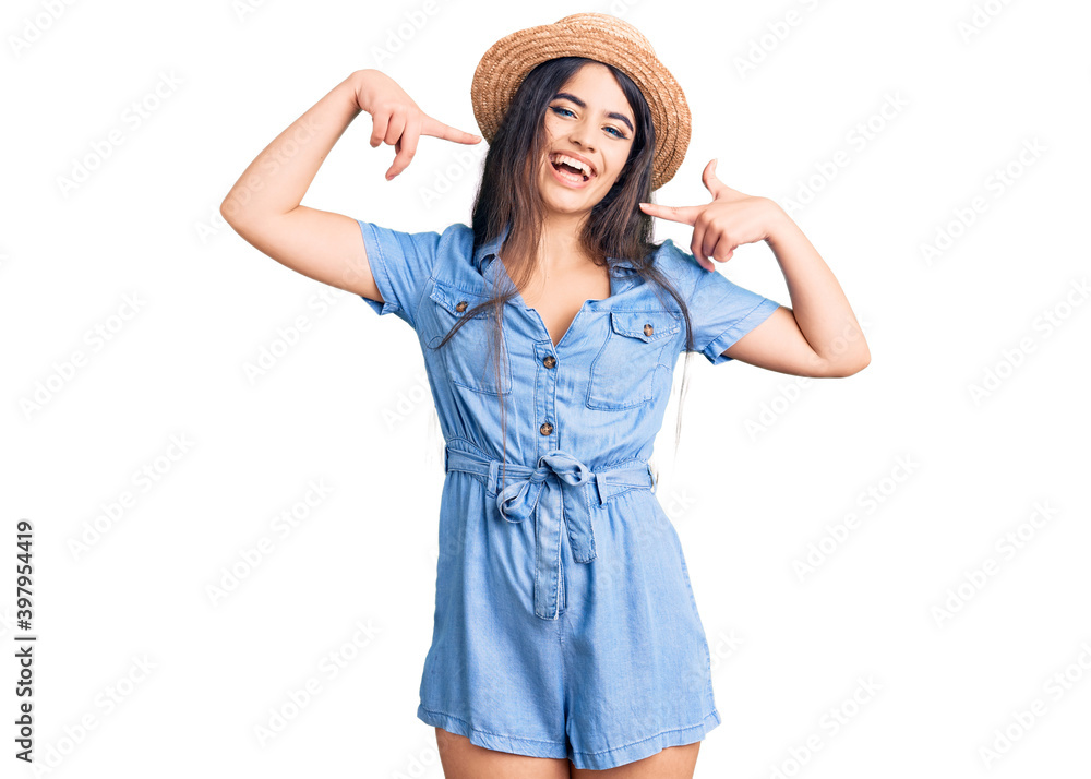 Brunette teenager girl wearing summer hat smiling cheerful showing and pointing with fingers teeth and mouth. dental health concept. Brunette teenager girl wearing summer hat smiling cheerful showing and pointing with fingers teeth and mouth. dental health concept.