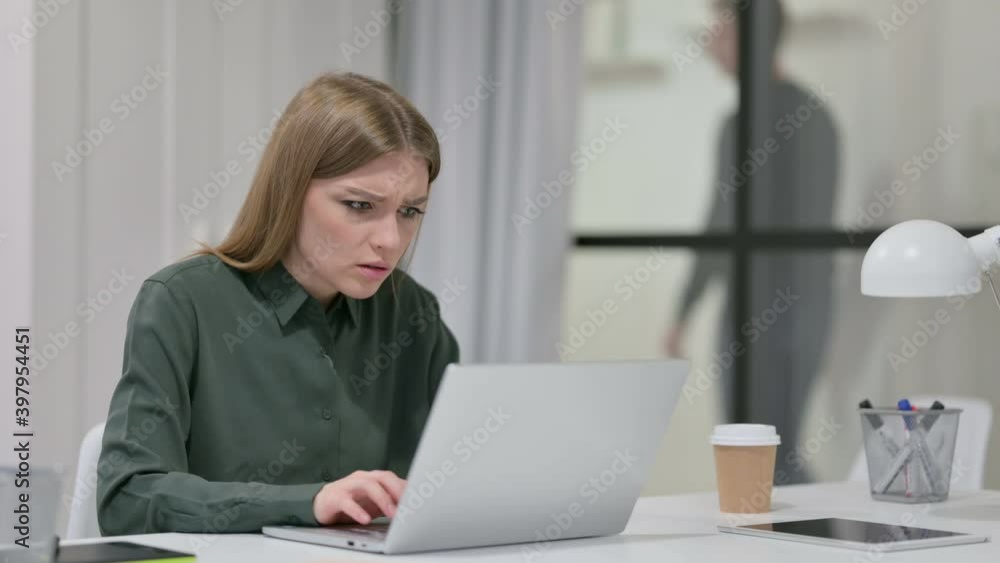 Young Woman Angry while using Laptop at Work Young Woman Angry while using Laptop at Work