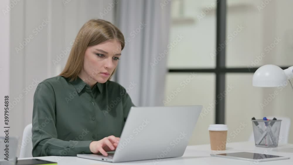 Young Woman Thinking while using Laptop at Work Young Woman Thinking while using Laptop at Work