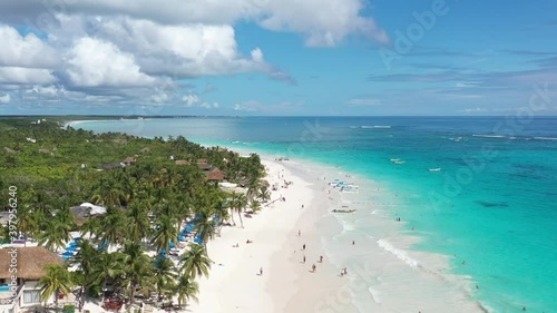 Espectacular vista aérea sobre Playa Paraíso, con muchos turistas caminando sobre la playa y bañándose en el mar, en Tulum, México.