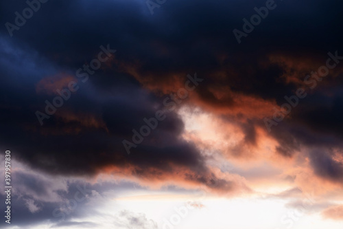 Stormy summer sunset with dark red anb blue clouds. Dramatic weather with atmosphere clouds. © Tengyart