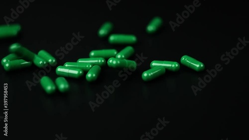 slow motion falling of green pills capsule