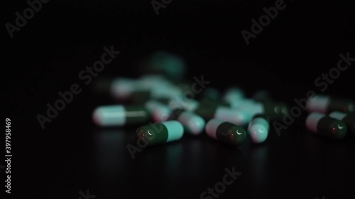 green and blue pills capsule on black background