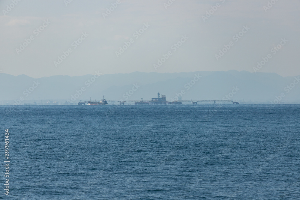 青空と伊勢湾の輸送用の貨物船の風景