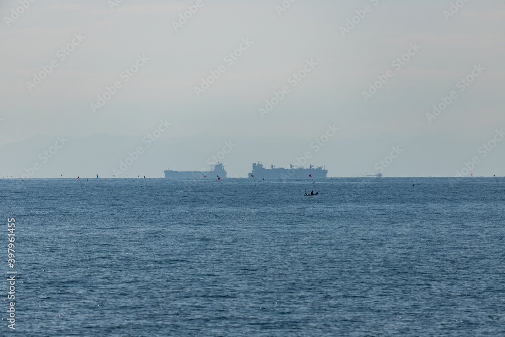 青空と伊勢湾の輸送用の貨物船の風景
