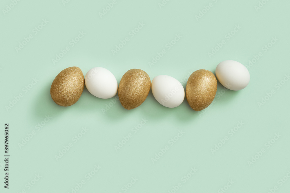 Top view easter composition with white and golden eggs, creative spring holiday flat lay with painted chicken egg Top view easter composition with white and golden eggs, creative spring holiday flat lay with painted chicken egg