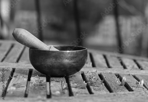 Tibetan singing bowl on a wooden table. black and white photo - Image