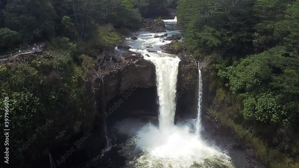 Aerial push-out shot of the Rainbow Falls and green nature in Hawaii