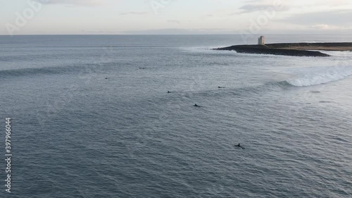 Aerial of surfers swimming towards lineup area behind break, duckdiving photo