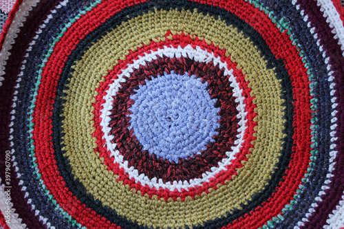 Background knitted rug from multi-colored threads around. Place for text. Selective focus. view from above