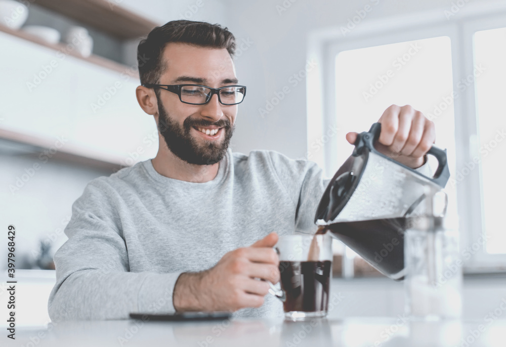 attractive man pouring himself a Cup of morning coffee attractive man pouring himself a Cup of morning coffee