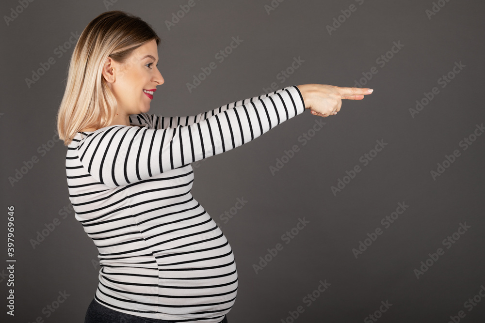 Pregnant woman posing on grey background Pregnant woman posing on grey background
