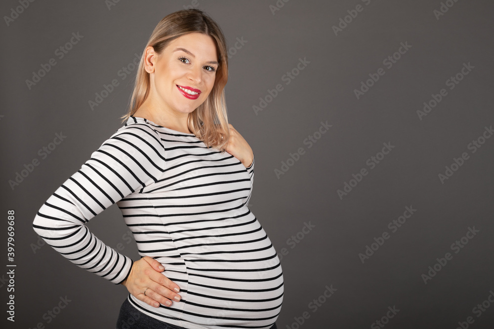 Pregnant woman posing on grey background Pregnant woman posing on grey background