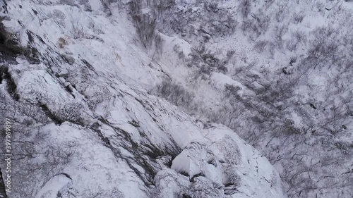 Frozen snowy mountain slope in the Scandinavian Mountain range - Bird's eye view Aerial tilt down photo