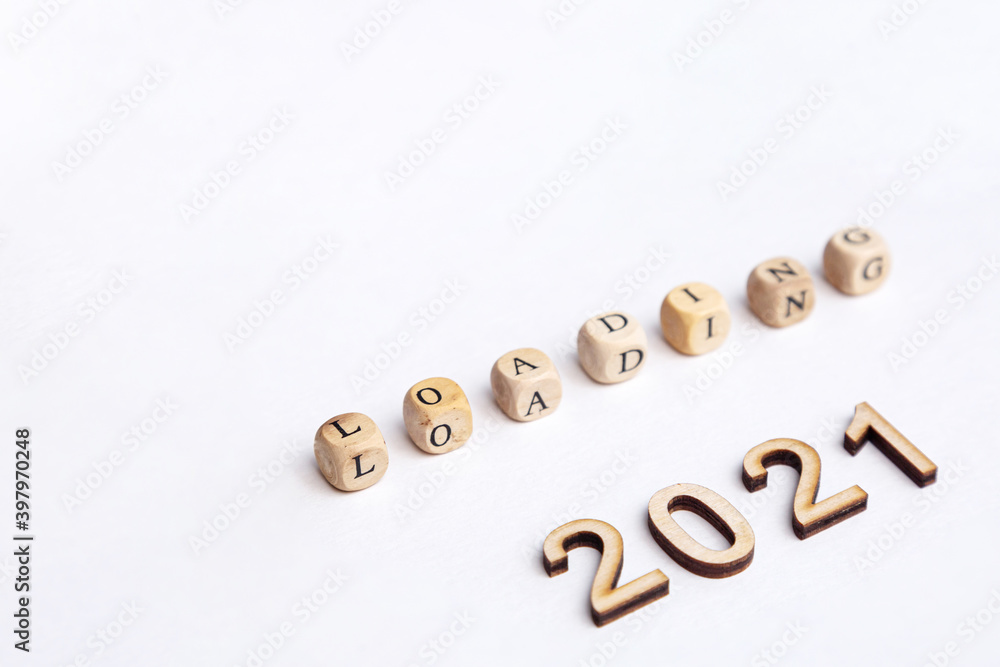 Loading 2021. Isolated on white background wooden cubes with letters Loading and wooden numbers 2021. New year concept Loading 2021. Isolated on white background wooden cubes with letters Loading and wooden numbers 2021. New year concept