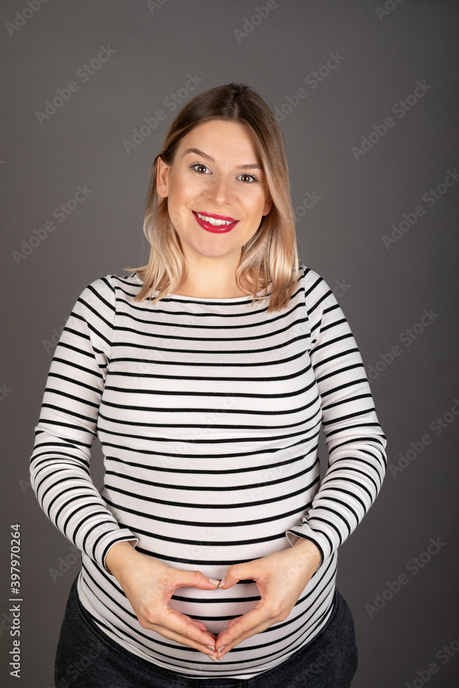 Pregnant woman posing on grey background Pregnant woman posing on grey background