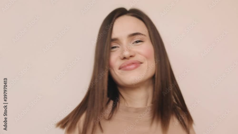 Emotions of people. Teen girl dancing. Funny unusual brunette woman hair having fun, hands up, grimaces, smiling, dancing in studio against beige background. Music, dance concept. Emotions of people. Teen girl dancing. Funny unusual brunette woman hair having fun, hands up, grimaces, smiling, dancing in studio against beige background. Music, dance concept.