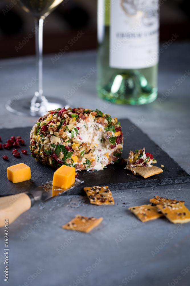 Cheese ball on black galvanized stone board served with wine and crackers. Charcuterie for dinner, cheese snack, copy space