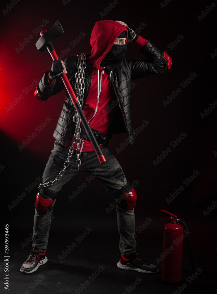 a man in a Balaclava and hoodie with an axe and a fire extinguisher the image of a Protestant a man in a Balaclava and hoodie with an axe and a fire extinguisher the image of a Protestant