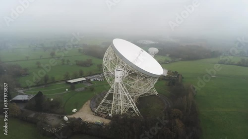 Aerial Jodrell bank observatory Lovell telescope misty rural countryside close right orbiting shot photo