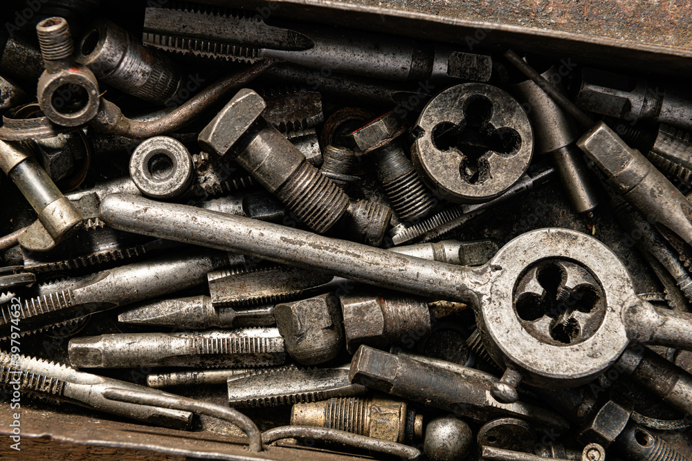 Old vintage iron toolbox full of drills and threading die tools as background