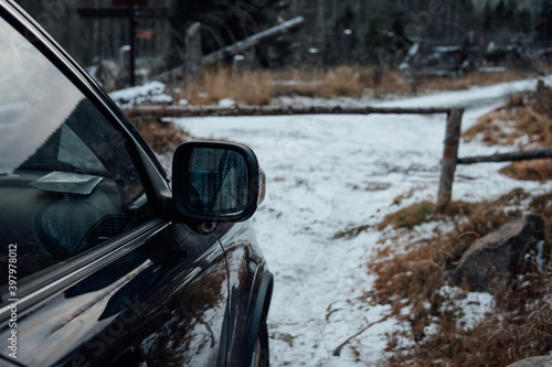 Rückspiegel eines Autos auf einem Forstweg im Wald