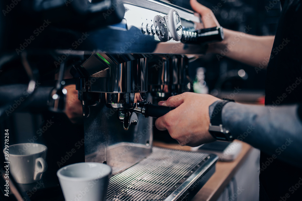 Barista hands at work - professional coffee machine in a cafe - making espresso