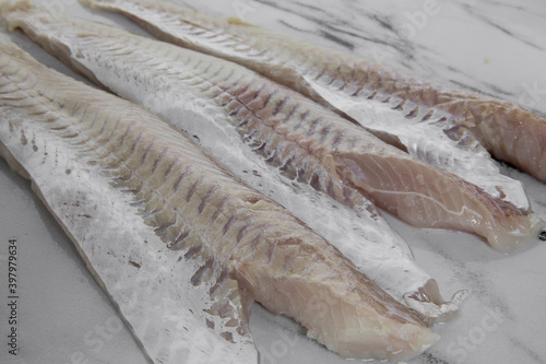 Culinary. Fresh raw fish meat texture. Closeup view of hake filets on the kitchen table. 