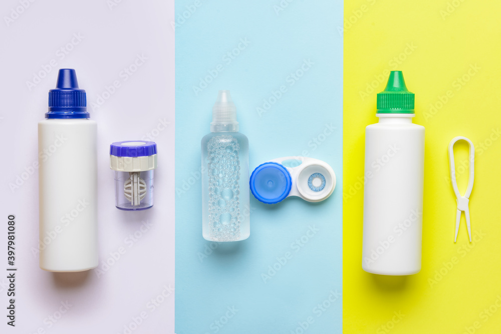 Containers with contact lenses, solutions and tweezers on color background Containers with contact lenses, solutions and tweezers on color background