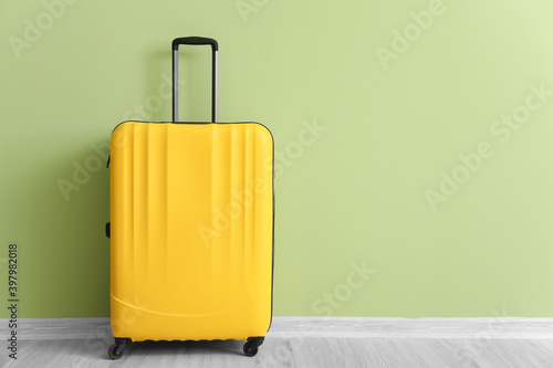 Packed suitcase near color wall